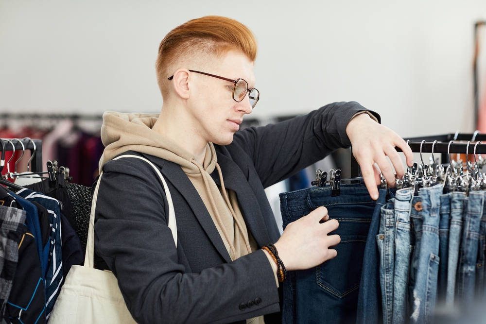looking through denim items in thrift store