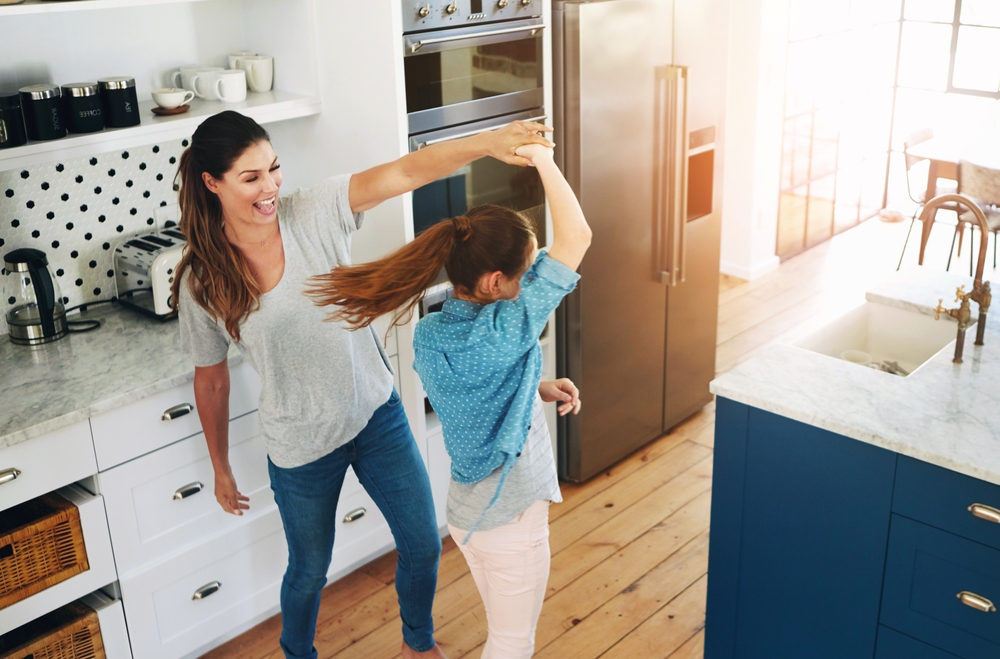 mother and daughter dancing to stay warm in the kitchen