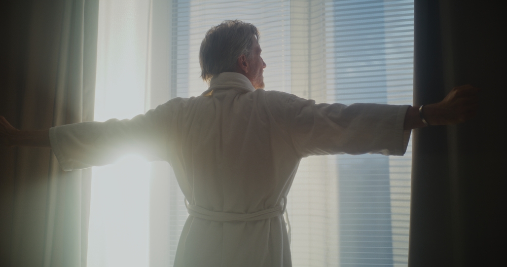man opening thick curtains