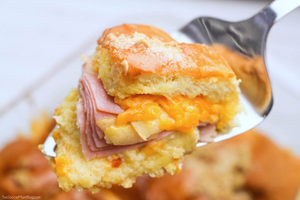 An irresistible combination of savory and sweet — these Buttery Baked Ham, Apple, & Cheddar Sliders are the perfect hearty fall football party recipe.