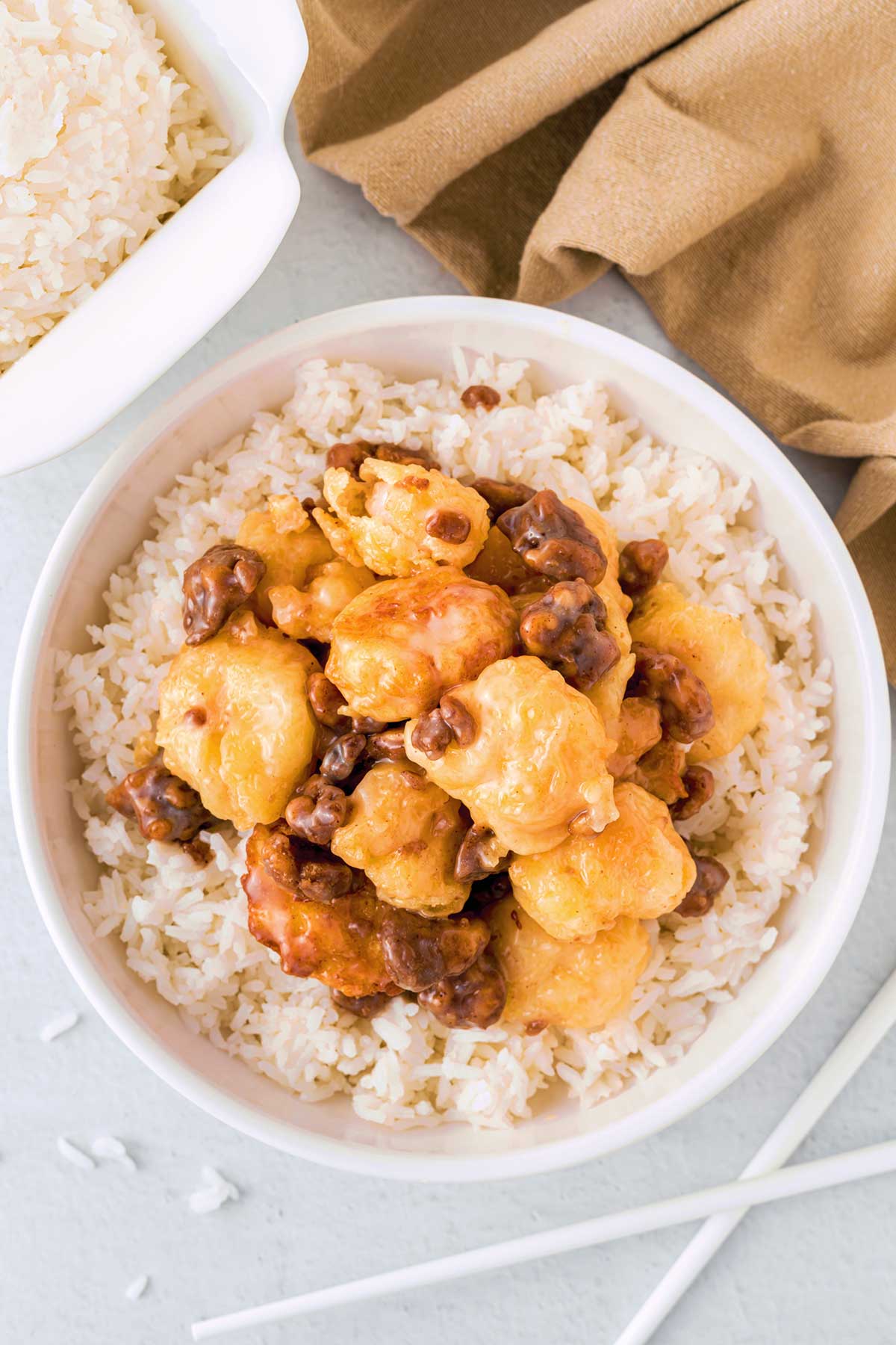 Top down view of honey walnut shrimp served on top of rice in a bowl.