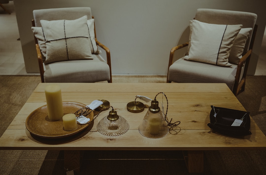 a wooden table topped with two chairs and a tray of candles