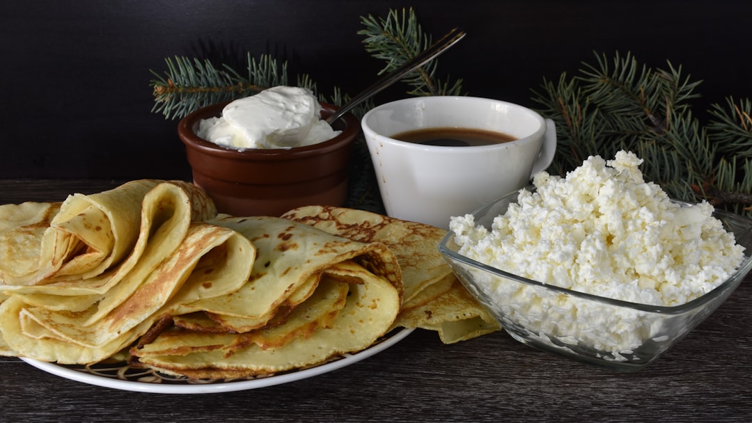 A table topped with a plate of food and a bowl of whipped cream