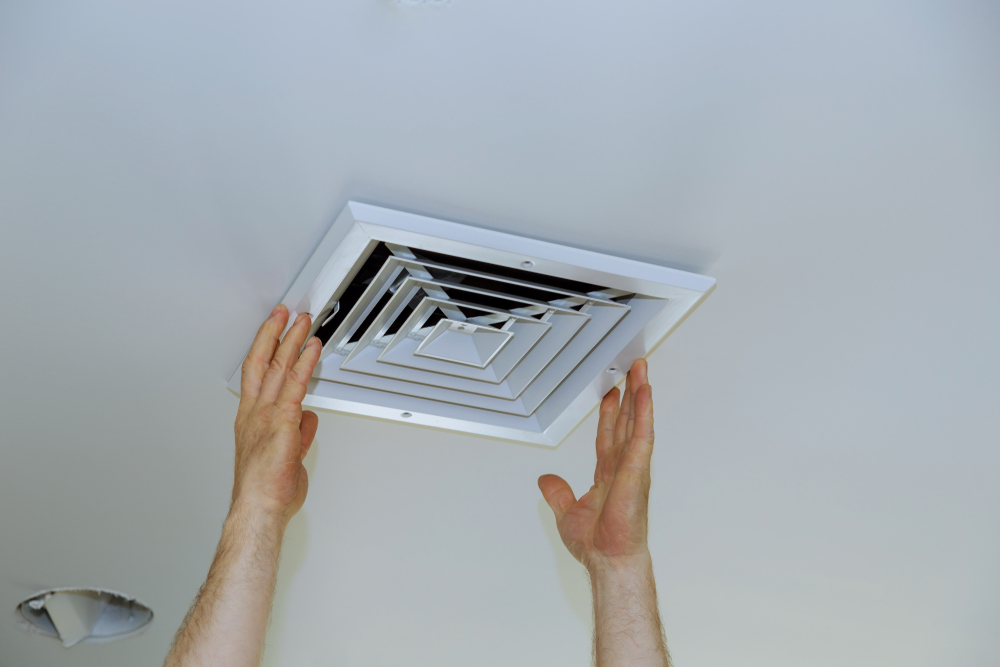 man checking bathroom fan cover