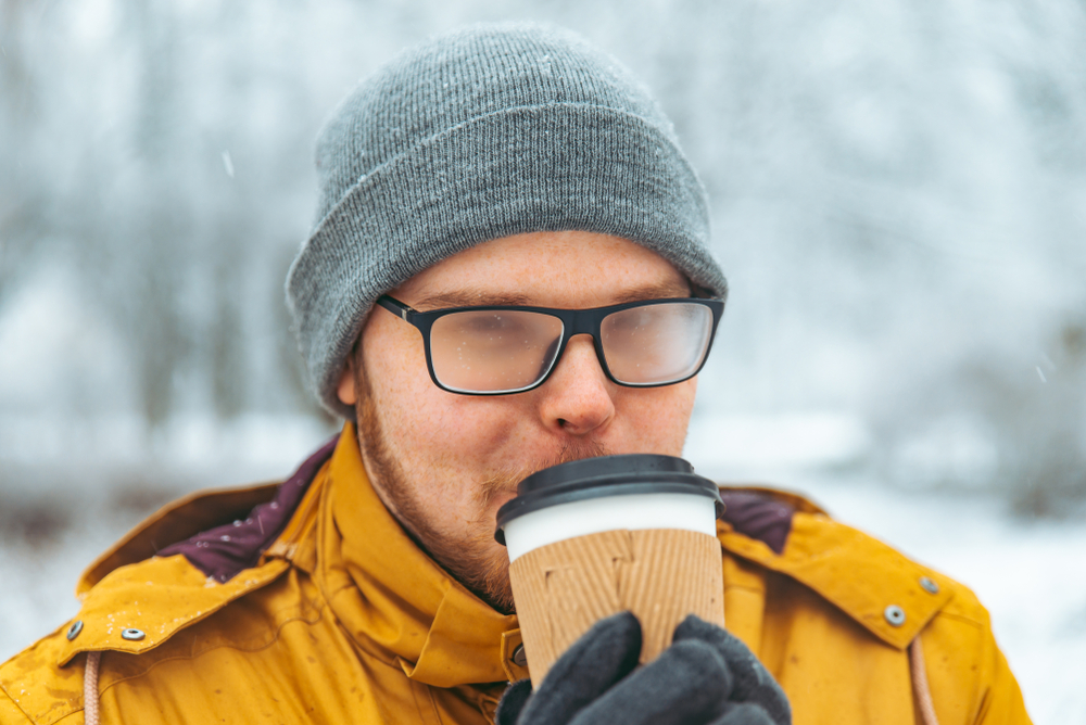 man drinking coffee on dog walk