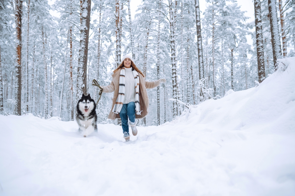 woman walking her dog in the snow