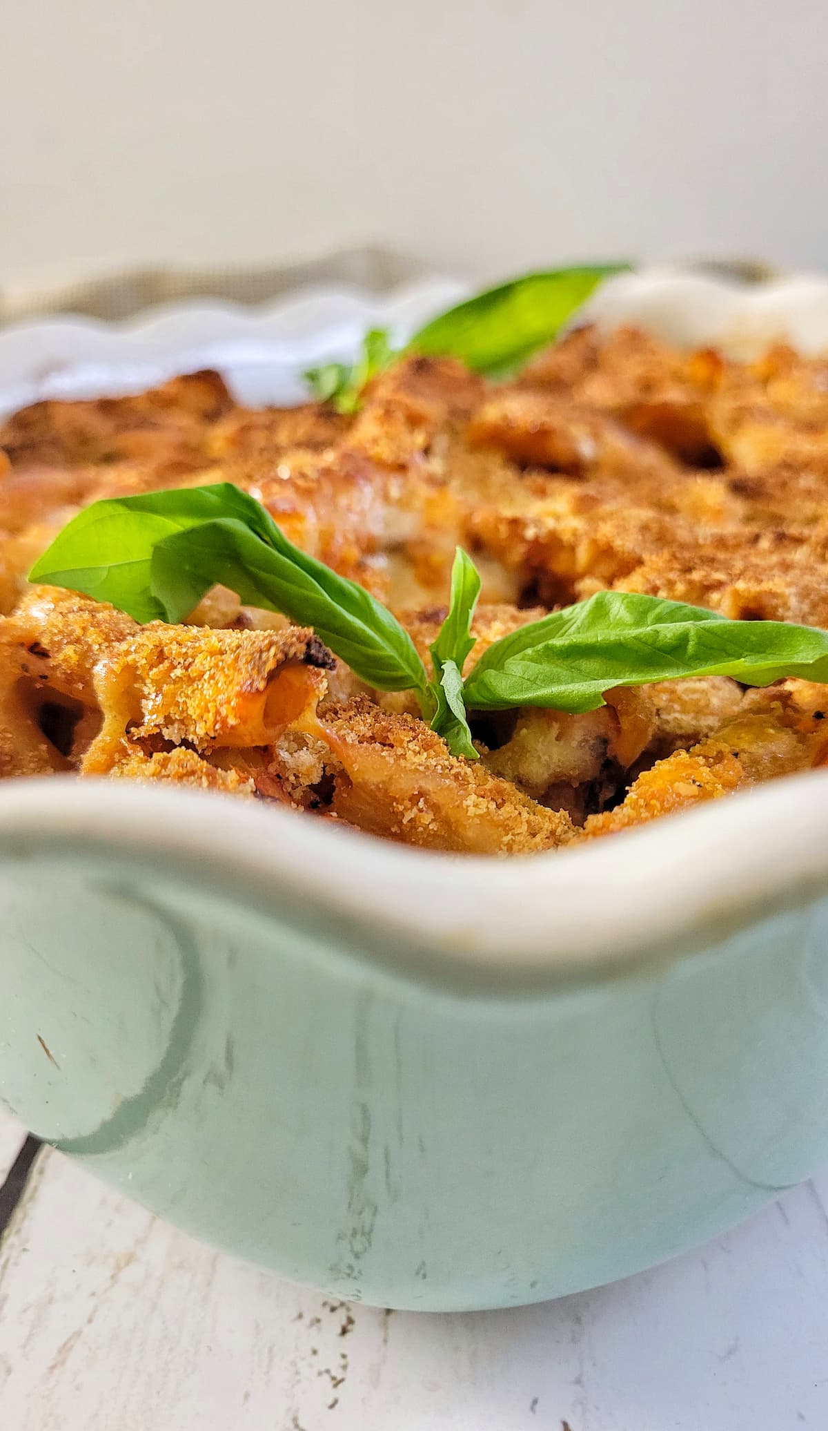 casserole dish with penne pasta in tomato sauce with fresh basil