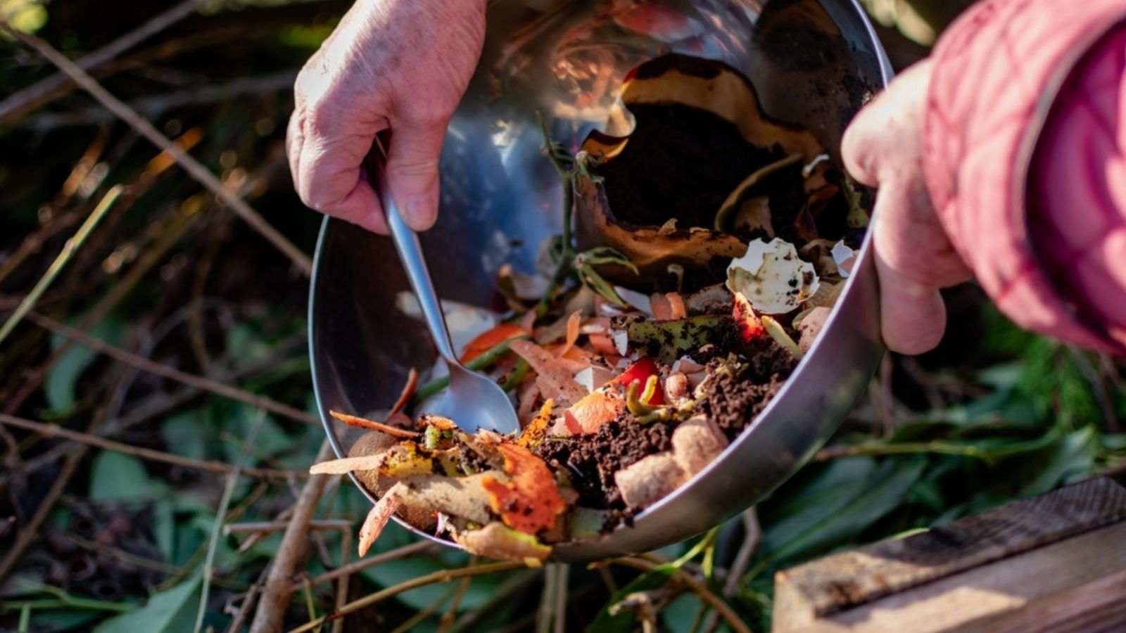 adding coffee grounds to compost heap
