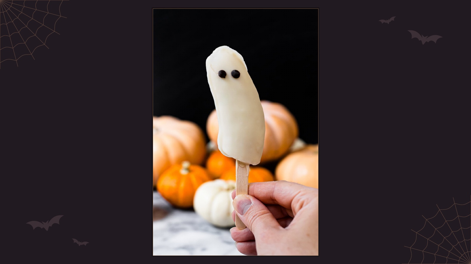 Frozen banana ghost pops dipped in white chocolate with chocolate chip eyes