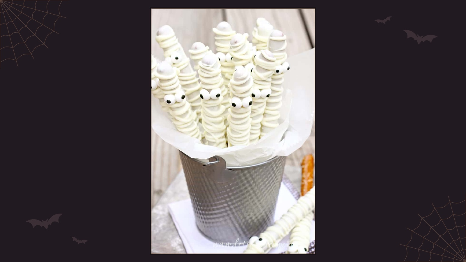 Pretzel rods decorated with white chocolate mummy bandages and candy eyes