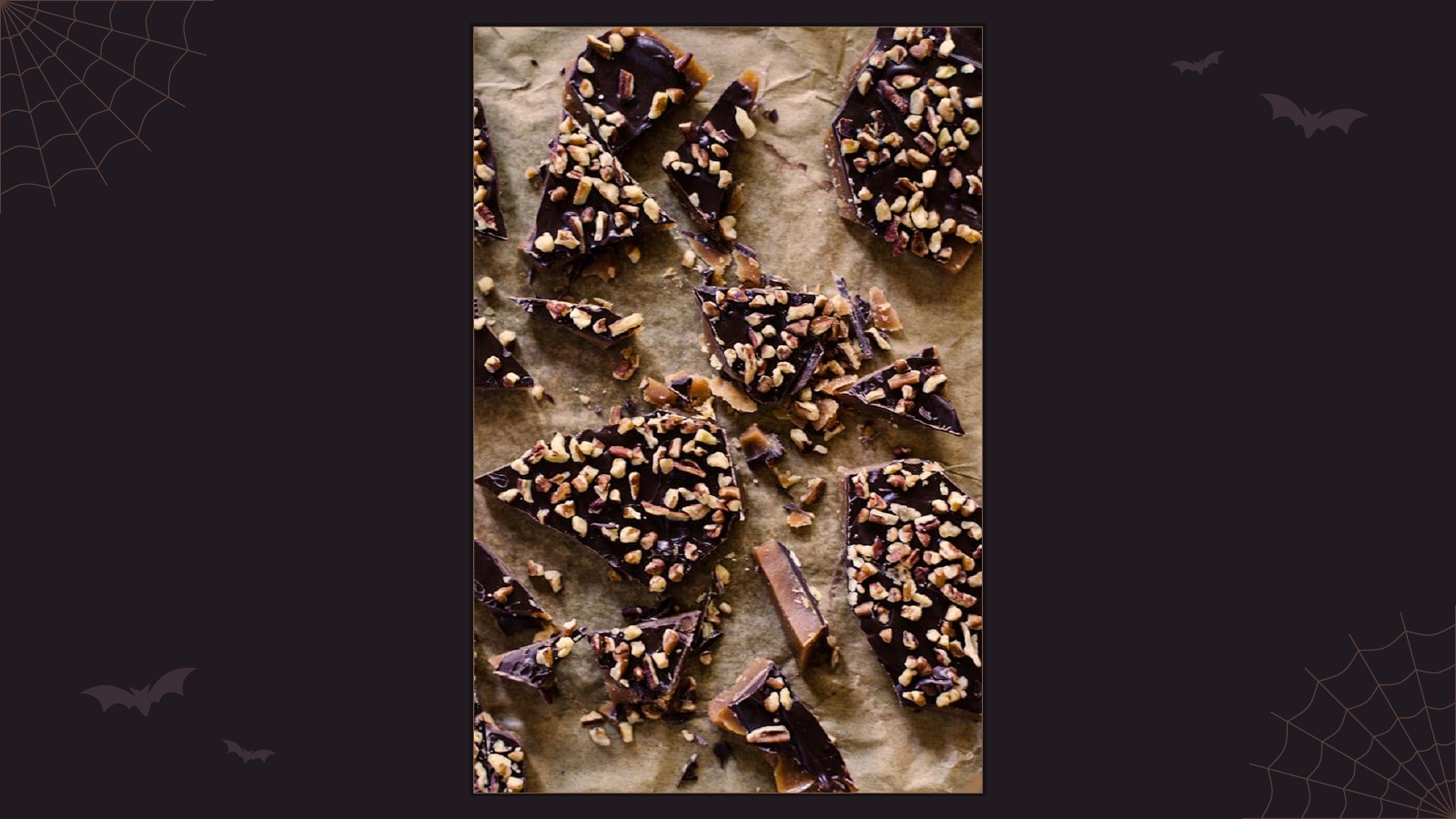 Broken pieces of homemade pumpkin spice toffee covered in dark chocolate and toasted pecans