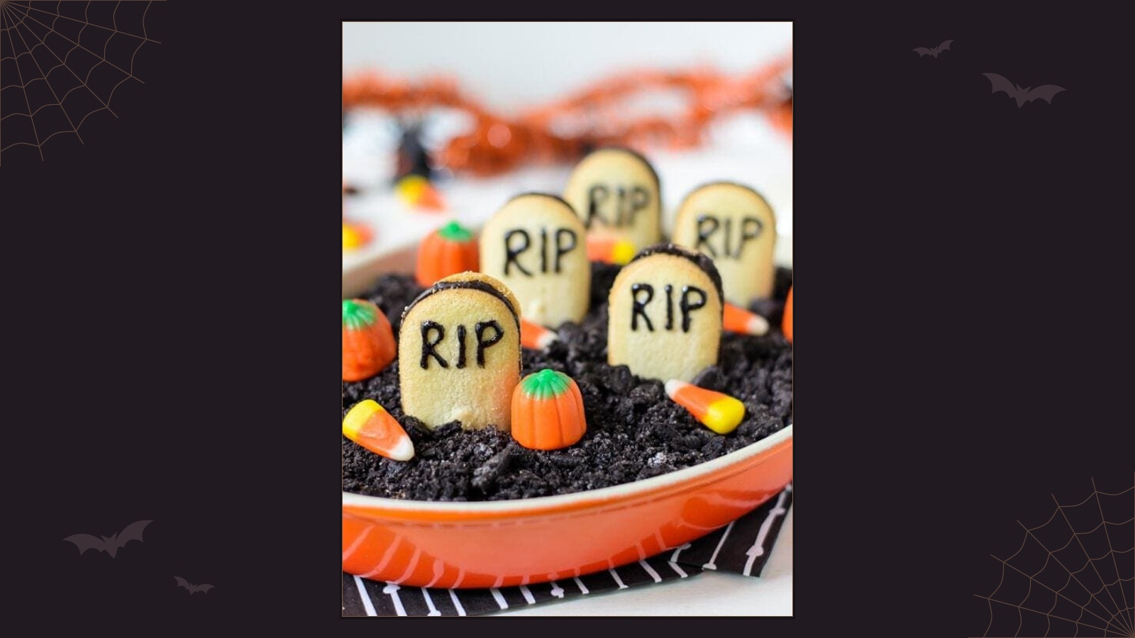 Chocolate cheesecake dip decorated with crushed cookie dirt, biscuit tombstones and candy pumpkins