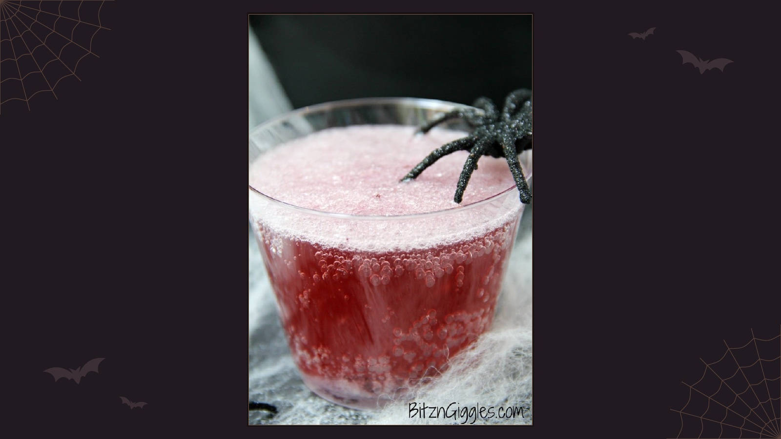 Halloween magic potion punch bubbling in a clear cup with spooky decorations