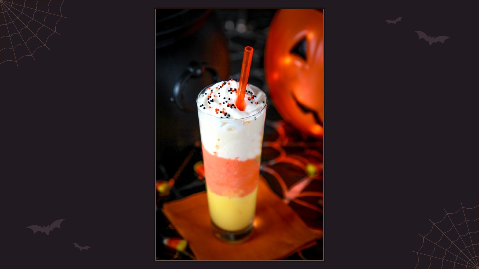 Layered candy corn milkshake in yellow, orange and white with whipped cream