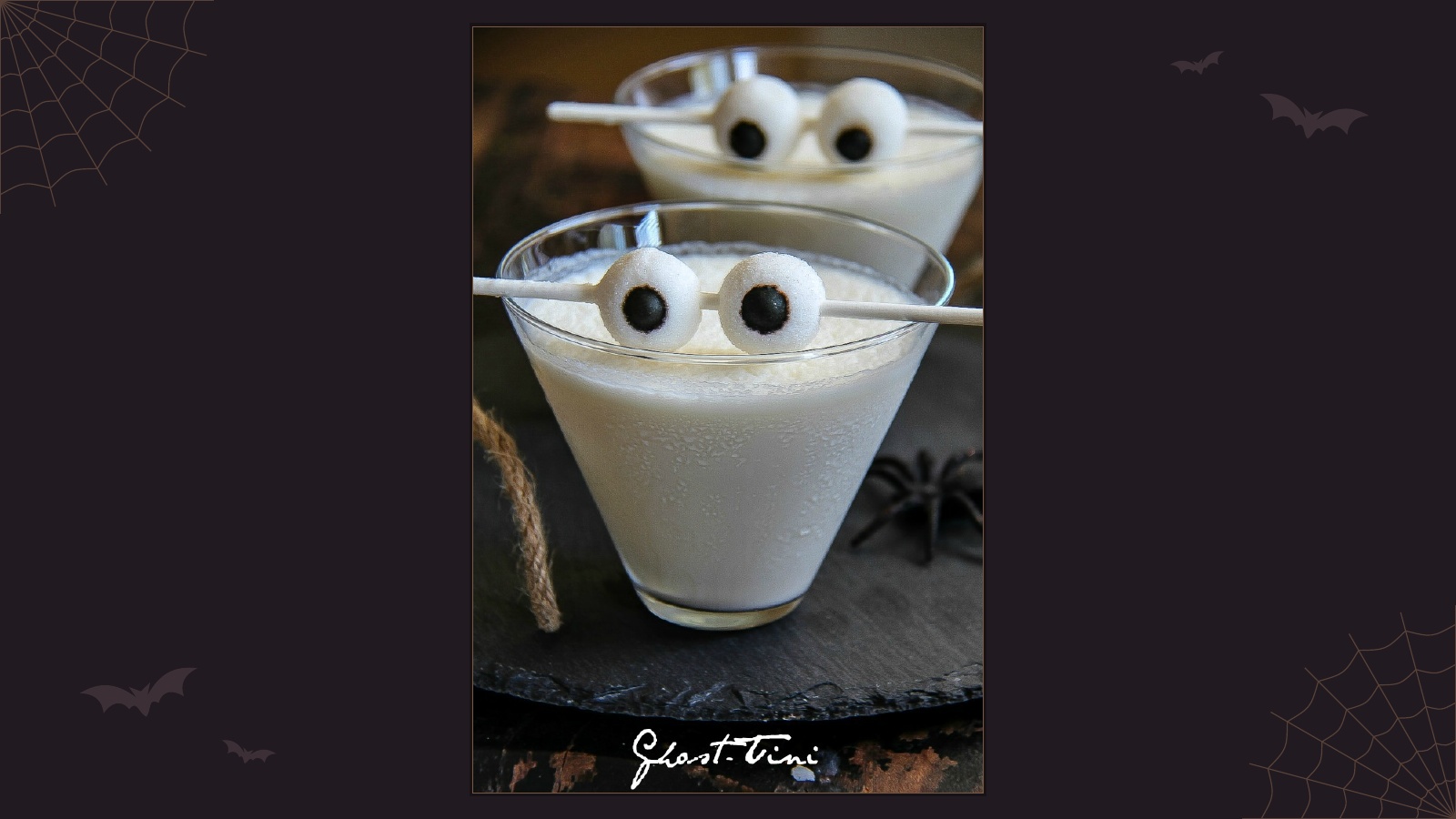 Creamy white Halloween ghost martini cocktails decorated with candy eyeballs on sticks