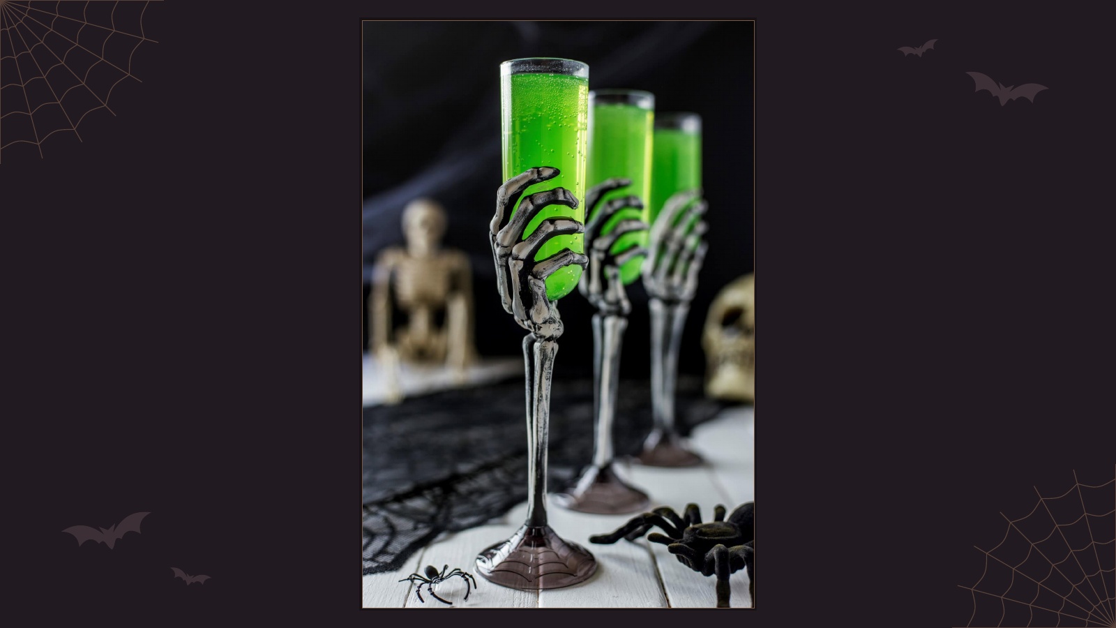 Bright green Halloween cocktails served in spooky skeleton hand glasses
