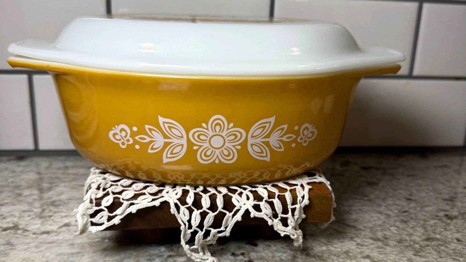 Gold Pyrex oval casserole with white Butterfly Gold decoration and a white glass lid