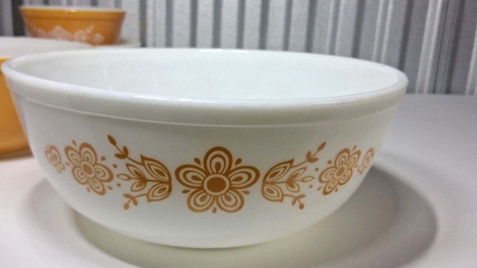 White Pyrex mixing bowl decorated with gold flowers, leaves and butterflies