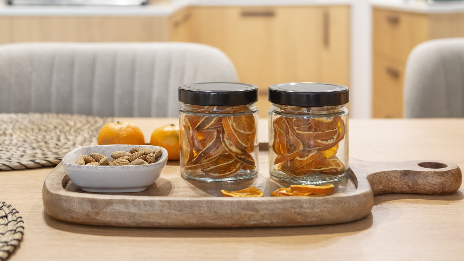 Two small glass jars of dried citrus slices with their black lids closed