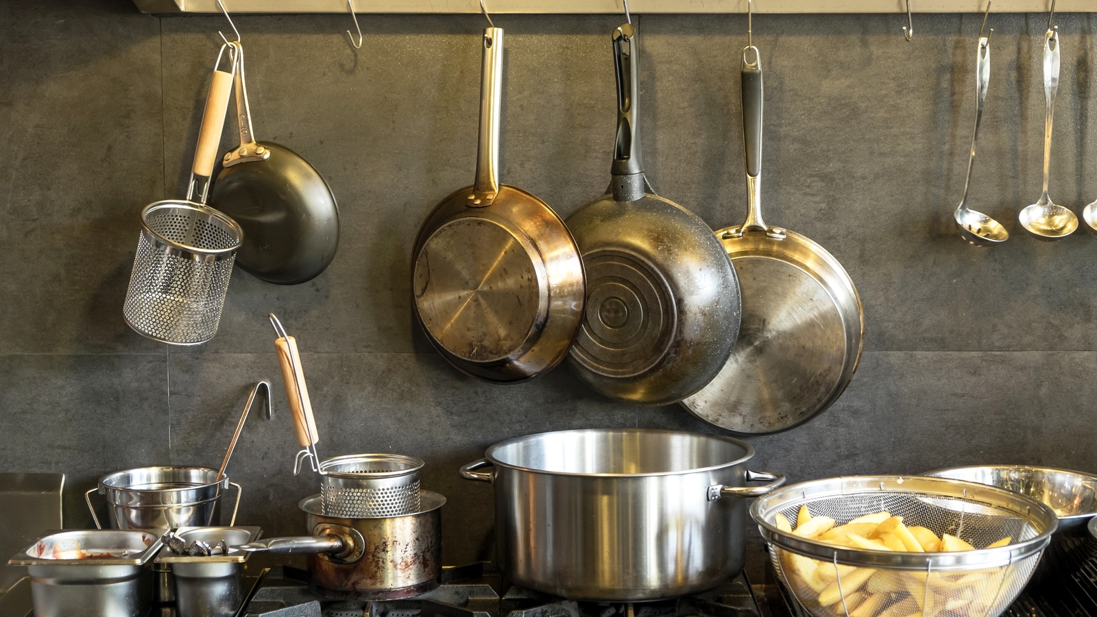 An assortment of metal cooking pots and pans in a working kitchen