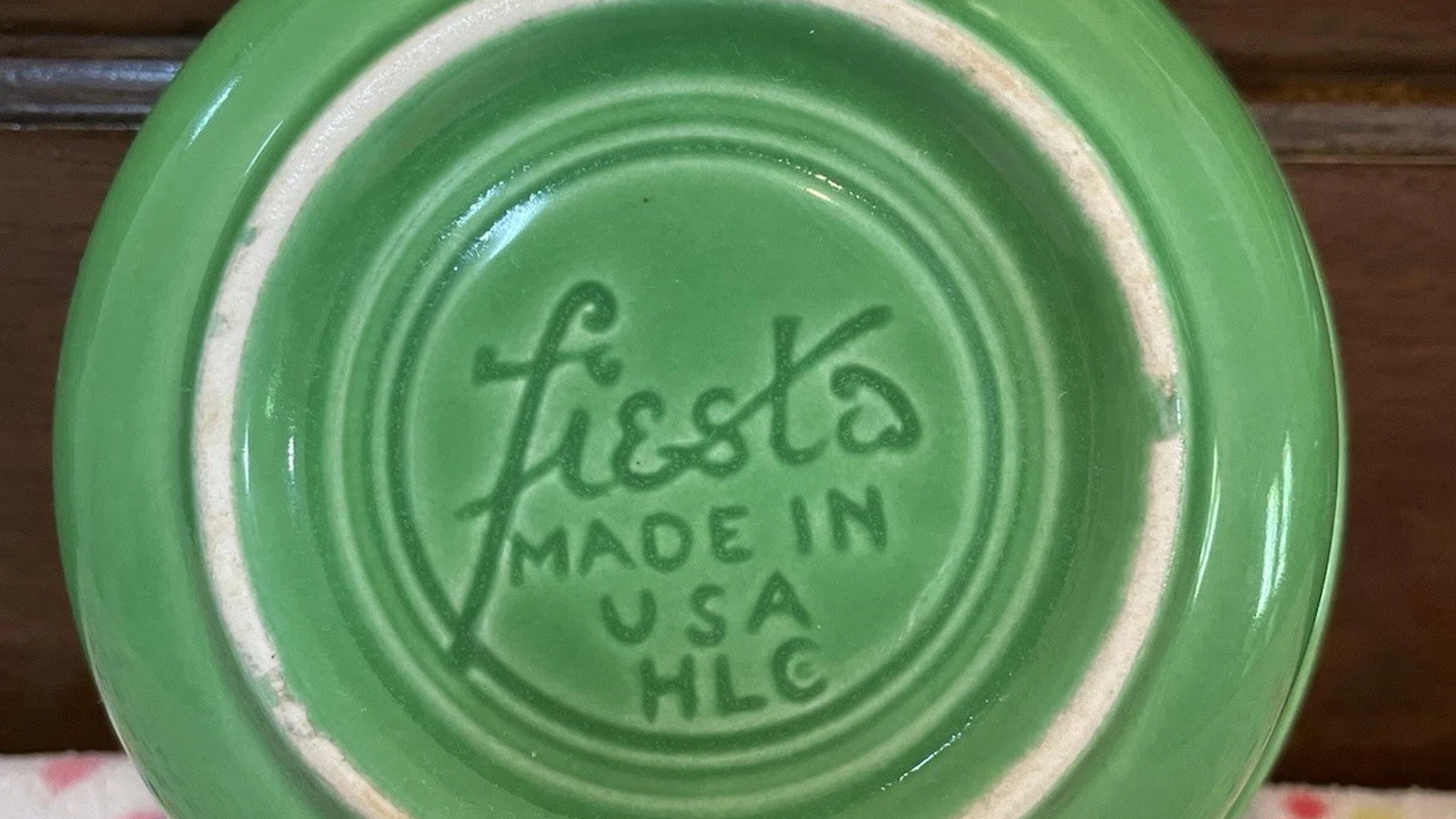 Impressed lowercase fiesta Made in USA HLC lettering on the underside of a vintage green fruit bowl.