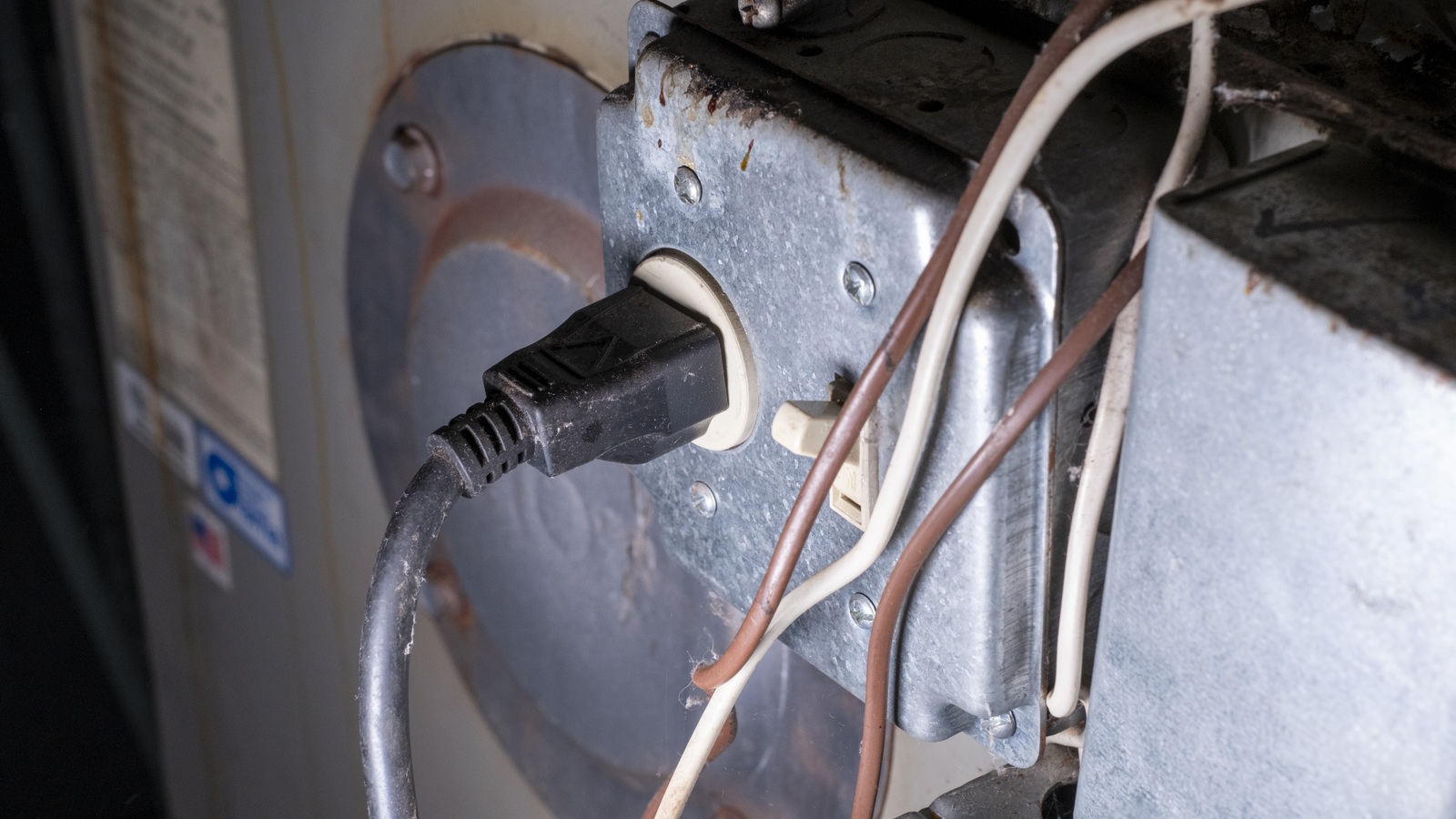 Close view of a furnace electrical power plug, switch housing, and wiring