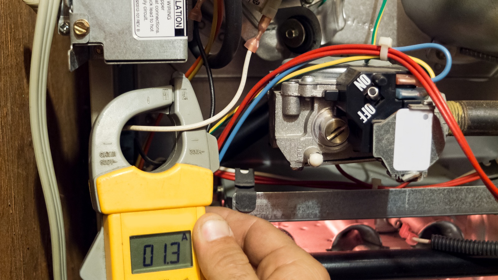 Electrical clamp meter and test leads being used inside a furnace