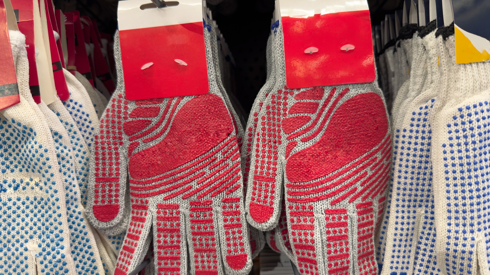 Knitted work gloves with several dotted and textured grip patterns on display