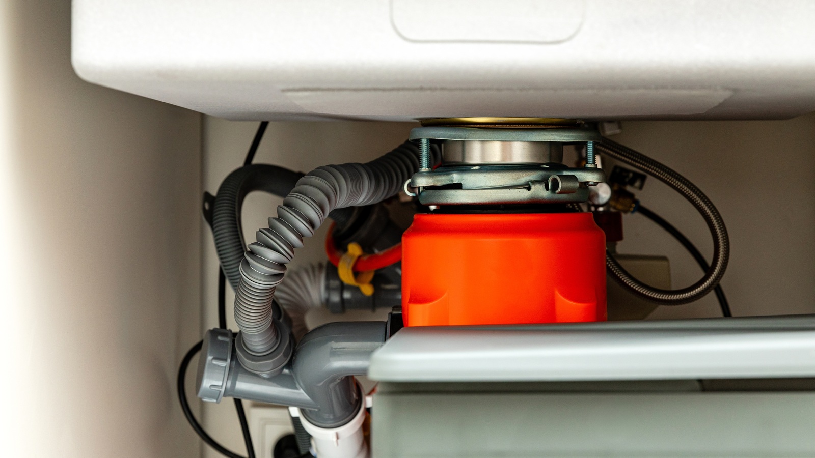 A food waste disposal unit fitted beneath a kitchen sink