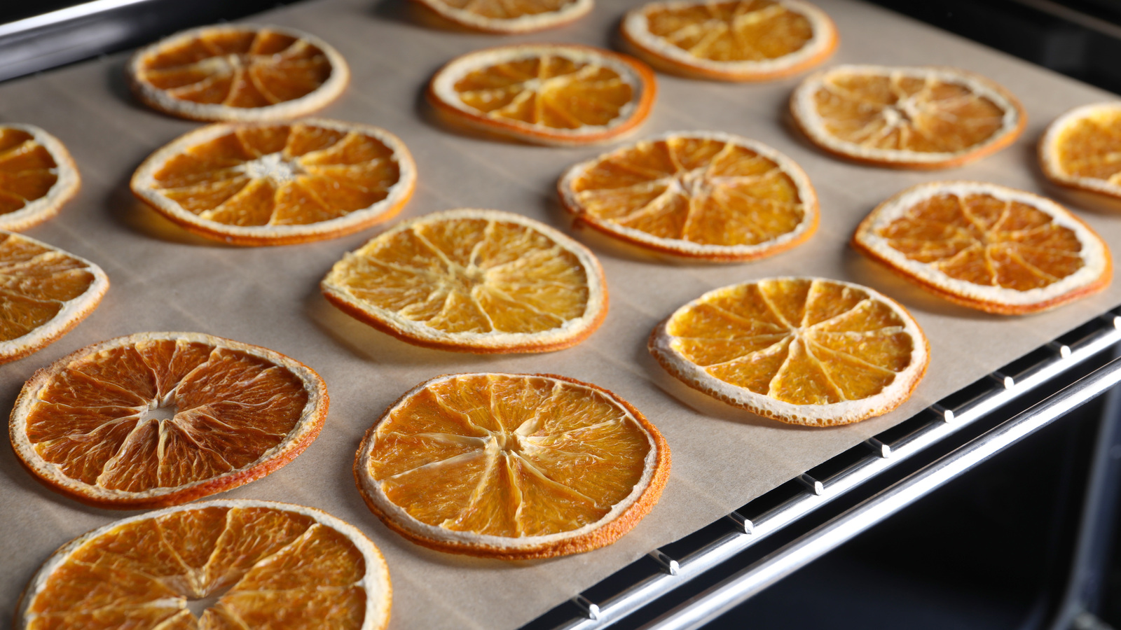 Orange rounds spaced apart on parchment paper on an oven tray