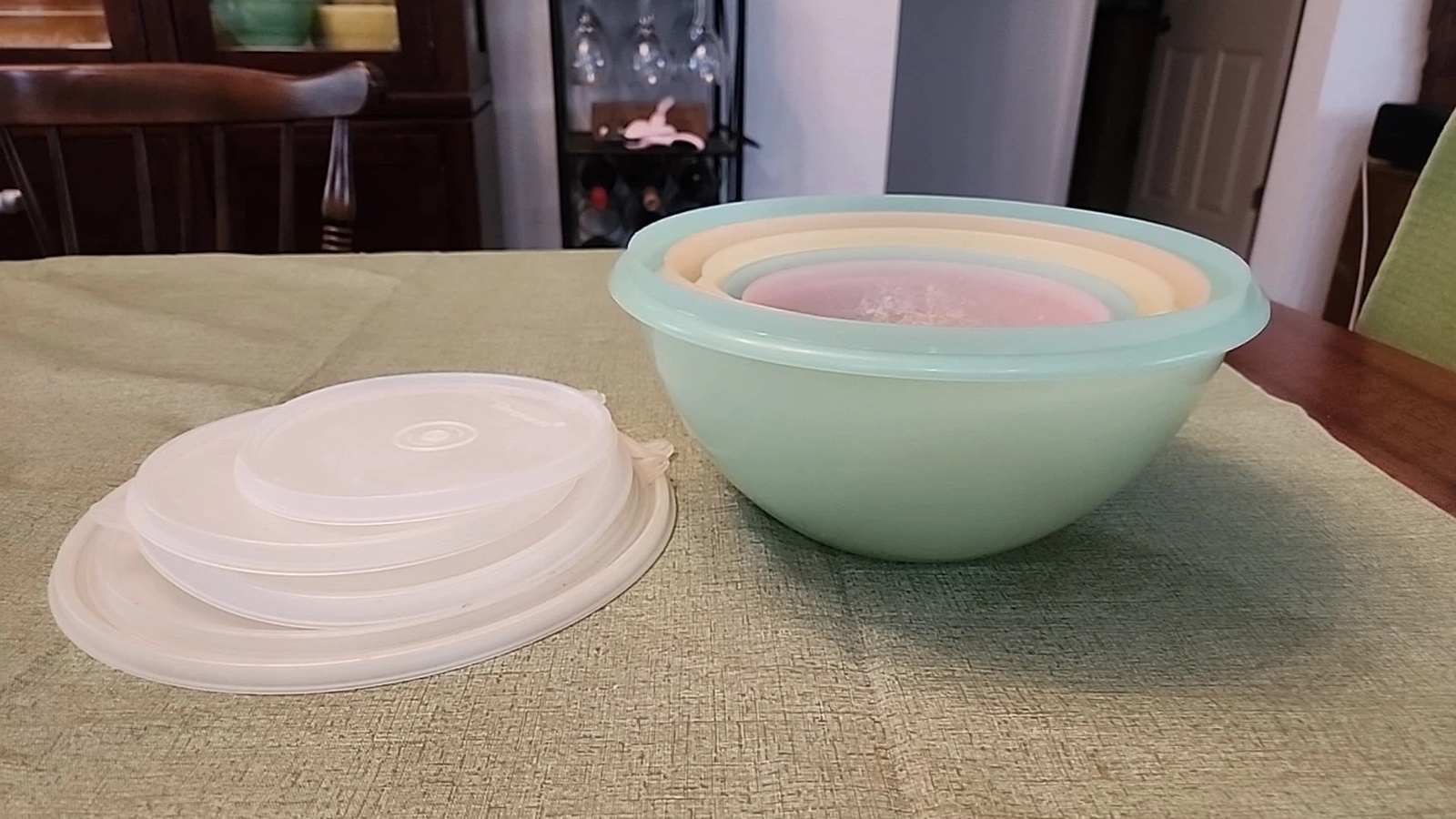 Five pastel Wonderlier bowls nested together beside their stacked translucent lids.