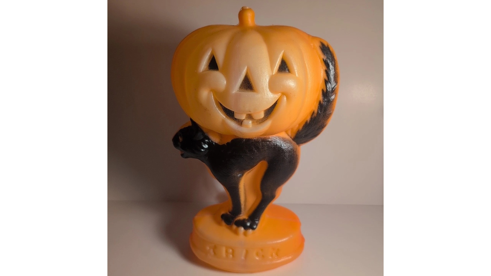 Full General Foam black cat carrying a smiling pumpkin above a base marked Trick