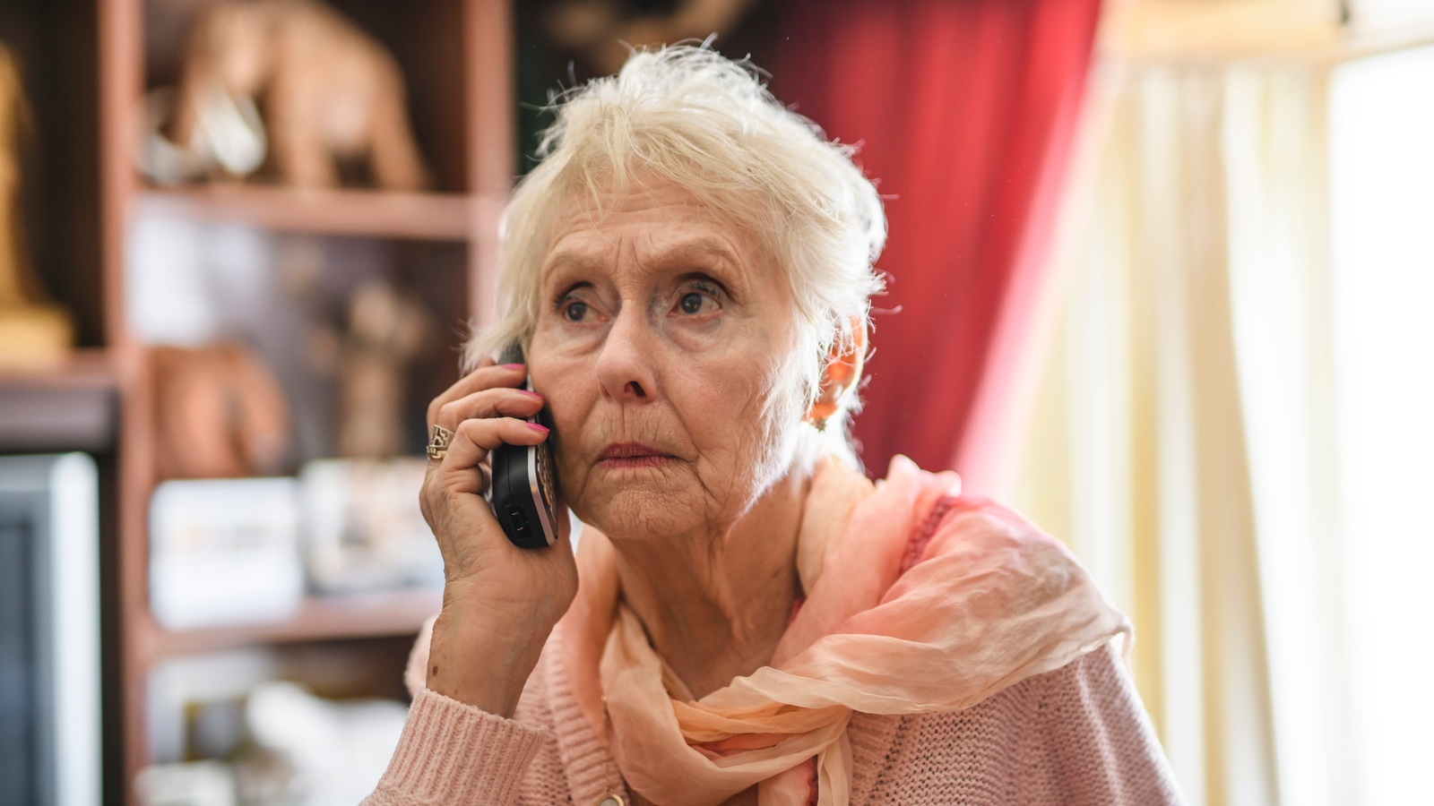 Older woman talking on a mobile phone at home