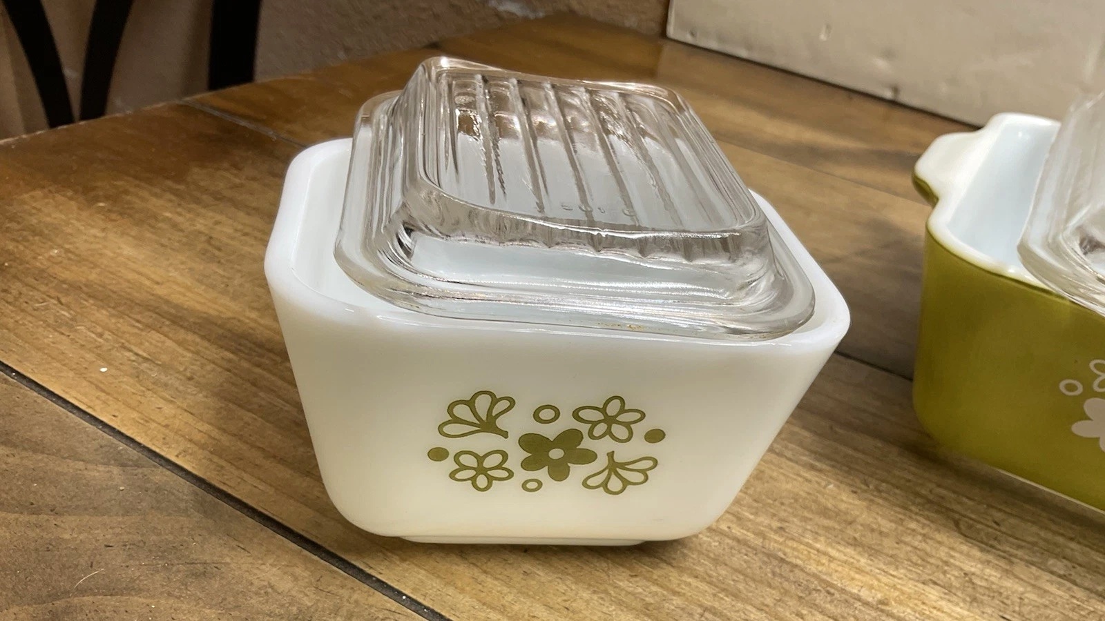 White Spring Blossom refrigerator dish with green flowers and dots beneath a ribbed clear glass lid