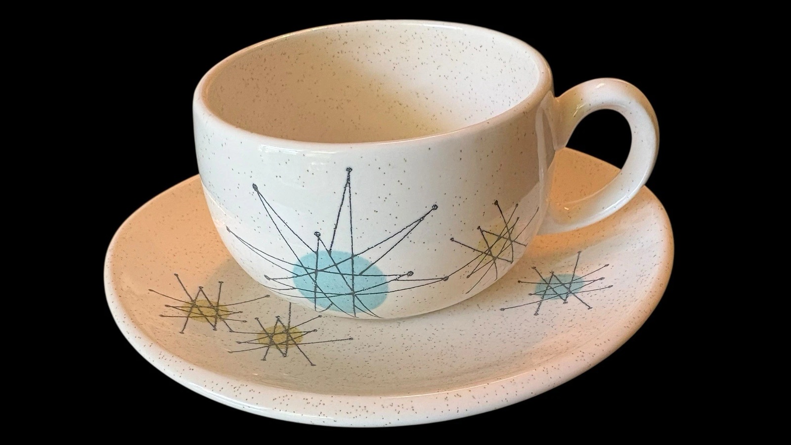 Franciscan Starburst cup and matching saucer with turquoise and yellow-green stars and a curved handle.