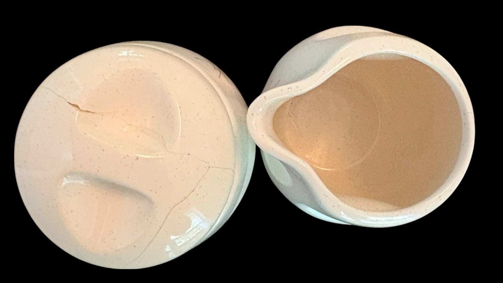 Underside of a repaired sugar-bowl lid beside the interior and pouring lip of a Franciscan creamer.