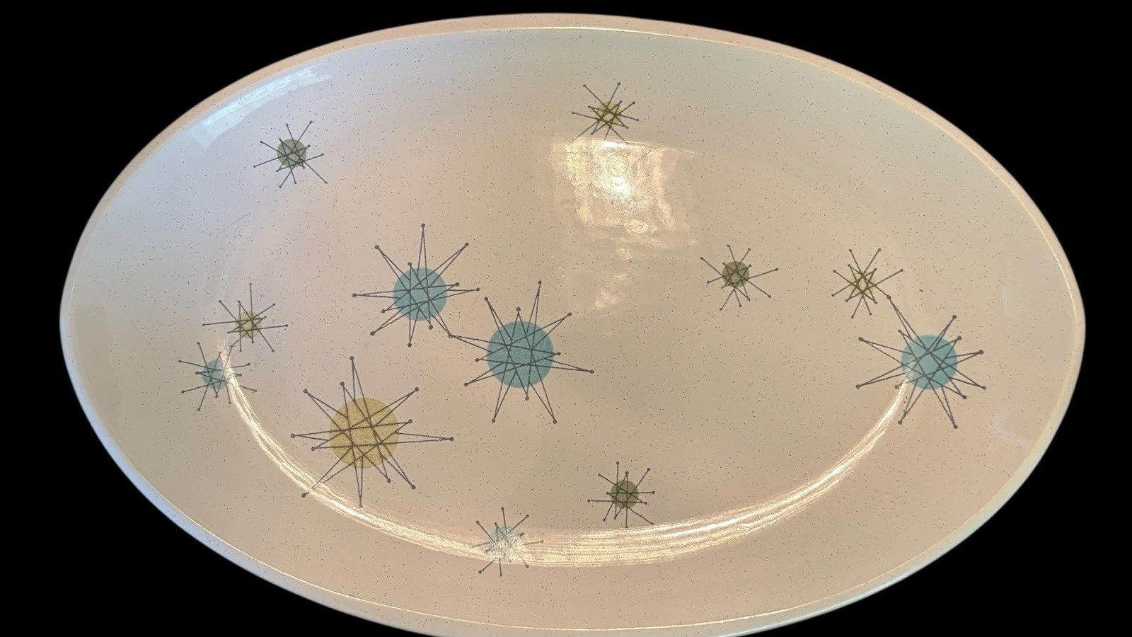 Oval Franciscan Starburst platter with turquoise and yellow-green atomic stars on speckled cream earthenware.